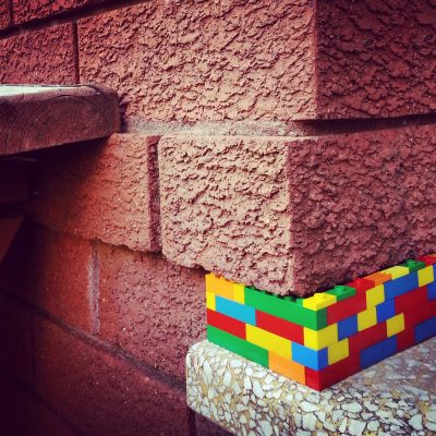 street-art-colourful-plastic-blocks-in-brick-wall-scaled-1